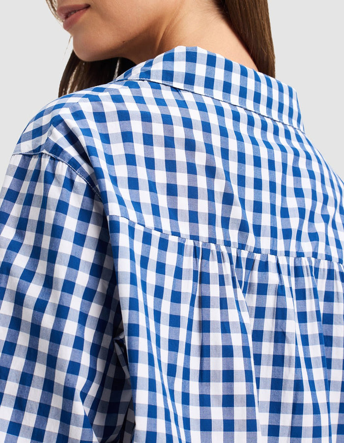 Close-up of a woman in profile wearing the Cozy Earth Women's Sutton Sleep Dress, highlighting the blue and white checkered fabric pattern, collar detail, and upper back.|Color:Pacific Gingham